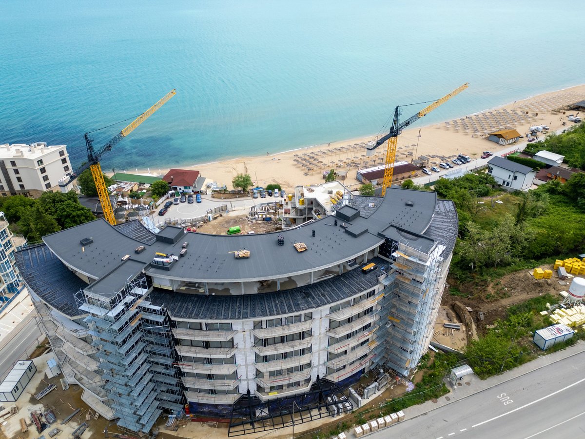 Vista aérea de desarrollo residencial en proceso de construcción junto a la costa, activo representado por MI Capital