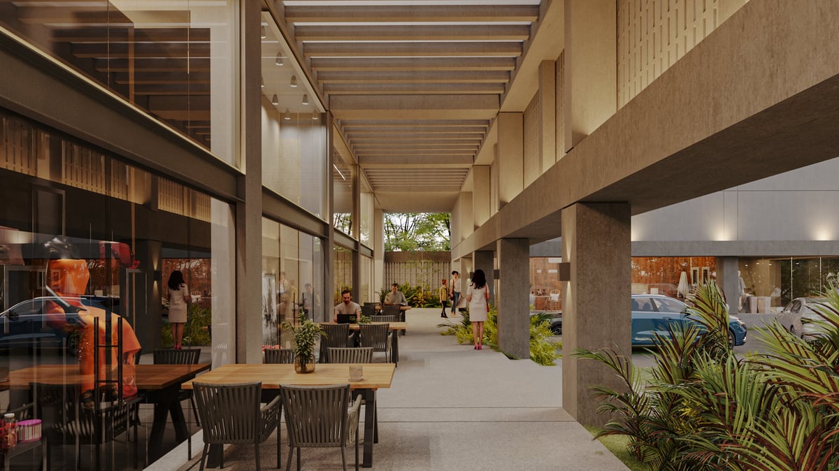 Modern covered outdoor shopping arcade with retail storefronts, dining areas, wooden ceiling beams, and potted plants lining the walkway