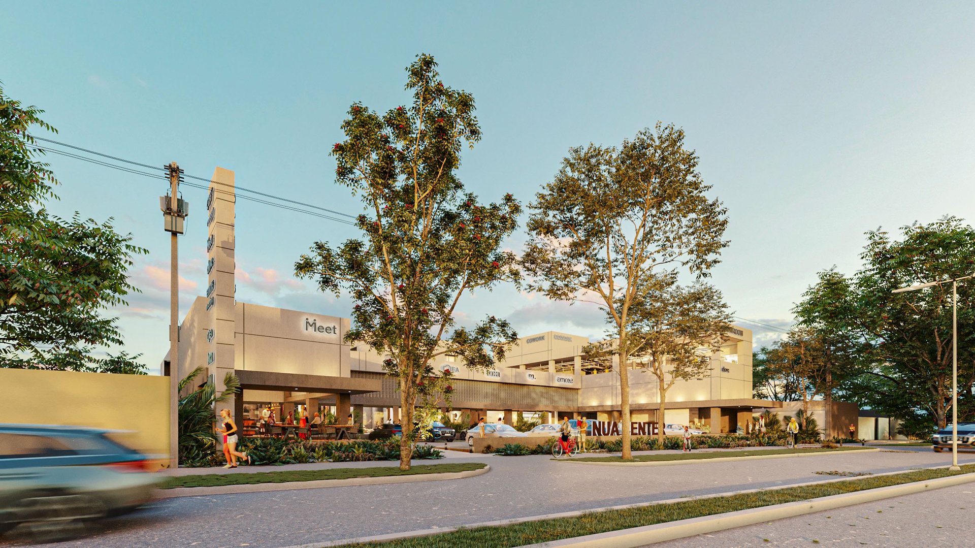 Modern commercial shopping center with beige buildings, tree-lined street, and passing vehicle on sunny day