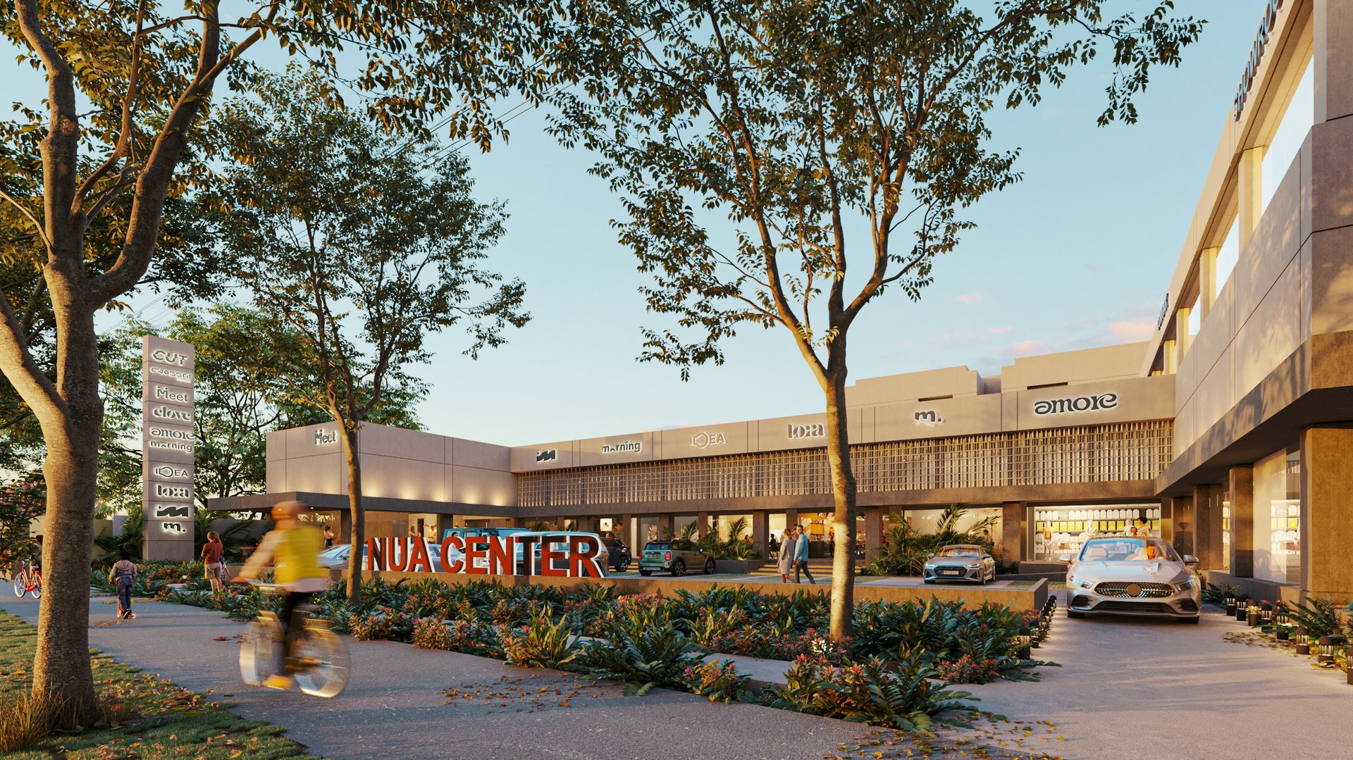 Modern shopping center exterior with brown brick buildings, large trees, parking lot, and Aldi Enti signage at dusk