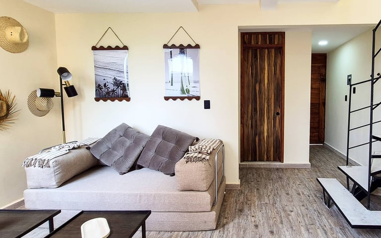 Modern apartment interior with beige sofa, gray pillows, wall art, and minimalist decor