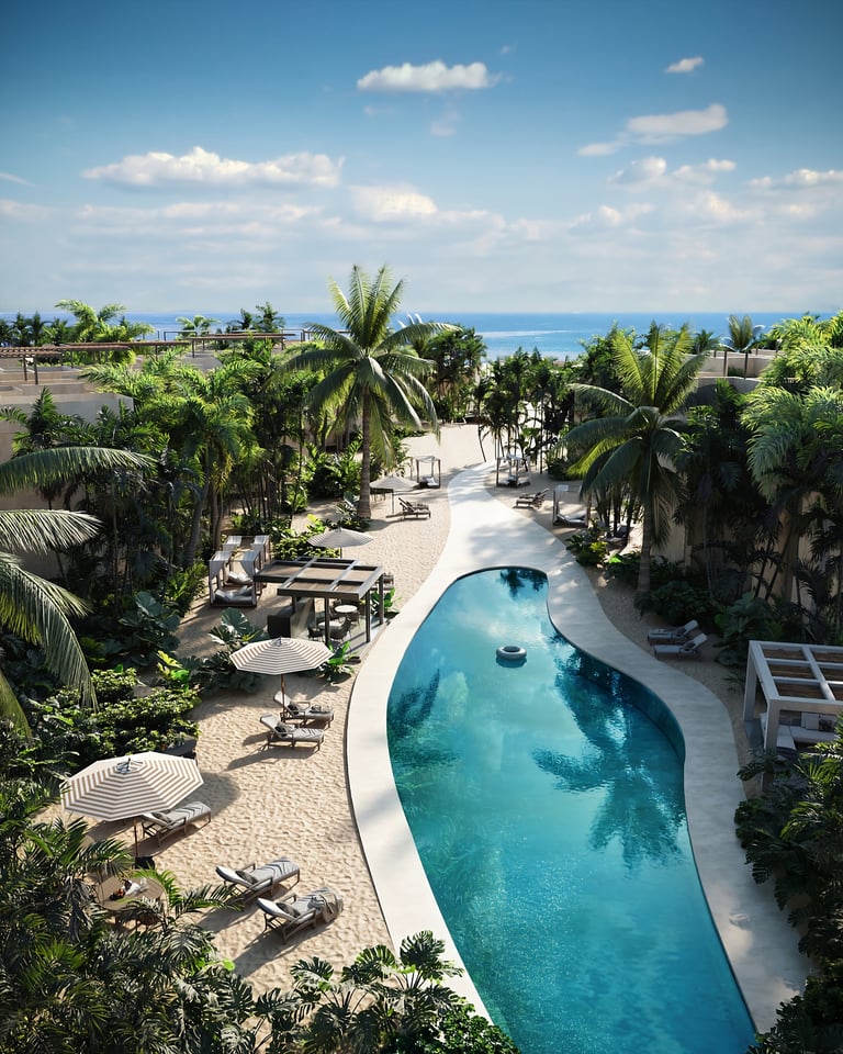 Aerial view of a tropical resort with a curved blue swimming pool, palm trees, sandy beach, and ocean horizon under blue sky