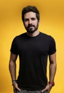 Man with beard wearing black t-shirt against yellow background